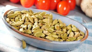 Cardamom seeds and fresh vegetables on a wooden table video