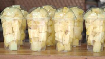 Enjoying fresh pineapple in plastic cups at a local market video