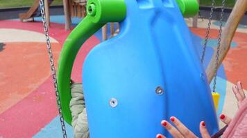 Children enjoy swinging at colorful playground video