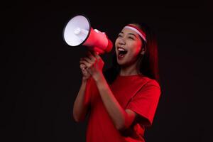 Portrait of Young Asian Woman with Megaphone Wearing Red Outfit, Indonesian Independence Day Concept Beautiful Isolated Background photo