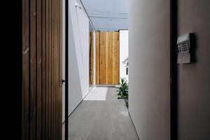 There is a hallway featuring a wooden door and a mailbox mounted on the wall photo