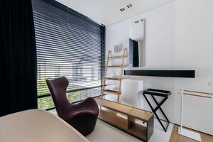 A cozy room with a simple chair and a tall ladder positioned in it photo
