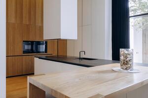 In a kitchen, there is a wooden table adorned with a vase filled with nuts photo