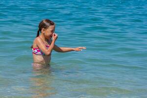 Caucasian happy and smiling child of 8 9 years closed her nose before diving and swimming in blue sea photo