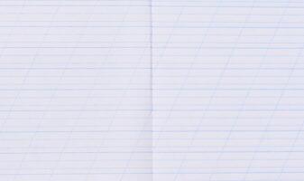 A close-up of a page from a school notebook with blue horizontal lines and diagonal guiding lines for handwriting practice photo