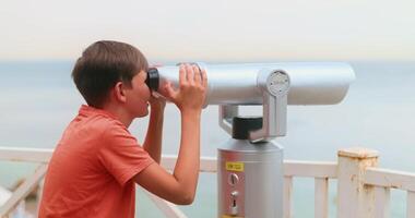 Boy Observing Ocean View Through Coin-Operated Binoculars video