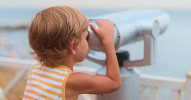 Child Exploring with Telescope at Seaside Viewpoint video