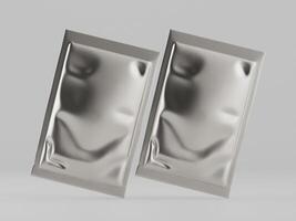 Two silver foil packets on a white surface photo