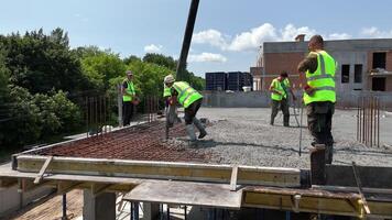 Construction workers pouring concrete on reinforced floor slab, High-rise building site with active teamwork during structural foundation work phase video