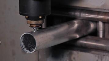 CNC laser head aligned with metal tube, high-precision cutting setup, Industrial machinery preparing for tube processing in automated production line video