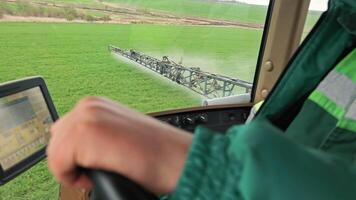 Tractor cabin interior with GPS screen and sprayer control, operator spraying field, High-tech agriculture using guided system for precise pesticide application video