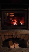Vertical screen. fireplace burns with glowing logs, creating haven of rustic warmth, haven draws viewers to cozy nights, haven enhances home decor videos, perfect for winter clips, background video