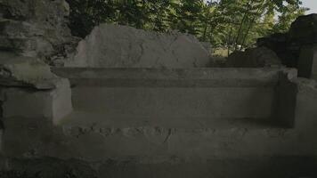 Fragmented Roman ruins at unidentified archaeological site surrounded by overgrowth, weathered stone structure with basin remains symbolizing lost ancient civilizations and historical decay video