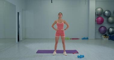 Girl athlete practices head tilting forward and backward in training session at gym studio video
