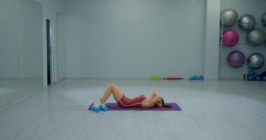 Fitness enthusiast performs bicycle crunches in a gym for core strength and conditioning exercises video