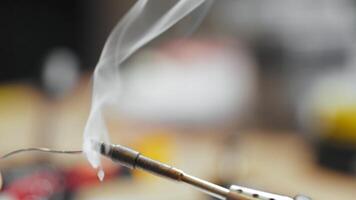 A Heated Soldering Iron Tip Coated with Rosin for Solder, Emitting Smoke. video