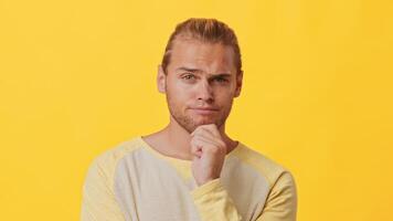 A young man with a mix of African and Caucasian descent stands in front of a bright yellow background. video