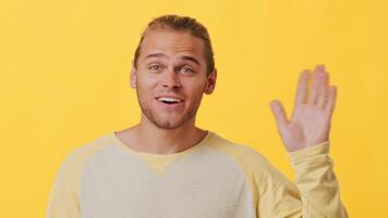 A cheerful young man with a blend of African and Caucasian features greets the viewer with a wave. video