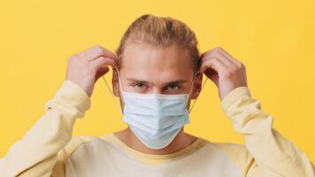 A young man with a blend of African and Caucasian features stands confidently in front of a bright yellow background. His expression is calm and assertive, capturing a modern, youthful vibe. video