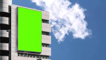 Chroma Key Green screen billboard on modern building for advertising with bright sky and moving clouds background video