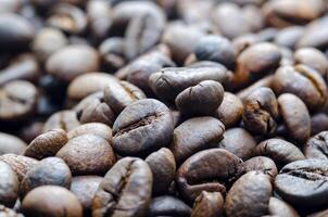 Close up view roasted coffee beans that highlights the texture and surface details of the coffee beans with customizable space for text.. photo
