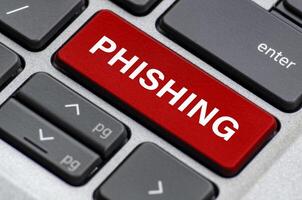 Phishing text on red keyboard key highlighting deceptive attempts to steal user information photo