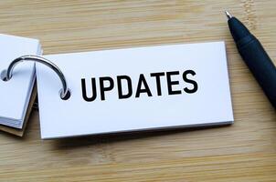 Updates text on notepad emphasizing timely communication and progress tracking in business photo