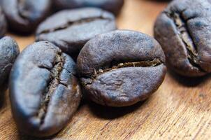 Close up of roasted coffee beans that highlights the texture and surface details of the coffee beans, with a focus on their deep brown color, natural cracks photo