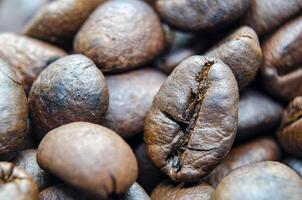 Close up of roasted coffee beans that highlights the texture and surface details of the coffee beans. Morning drinks concept photo