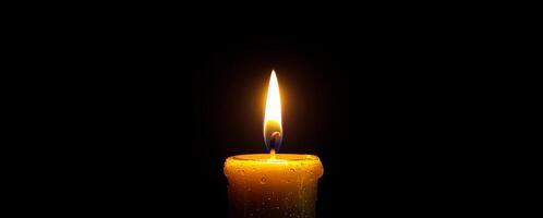 Warm glow of a candle flame in darkness. A single candle illuminated in a dim environment, with a vibrant flame flickering gently as droplets adorn its surface. photo