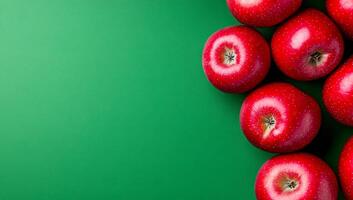 Fresh red apples on green background. Red apples arranged on a vibrant green surface create an inviting and fresh display ideal for healthy eating themes. photo