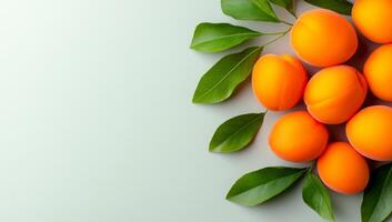 Apricots with green leaves. Bright orange apricots displayed alongside vibrant green leaves on a light background. photo
