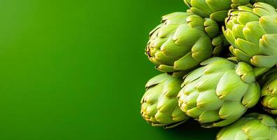 Fresh artichokes on green background. Fresh artichokes arranged beautifully against a vibrant green background, showcasing their natural texture and color. photo