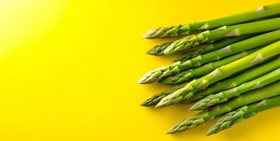 Green asparagus on yellow bg. Vibrant green asparagus spears arranged neatly against a bright yellow backdrop, showcasing their freshness and color. photo