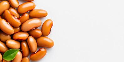 Vibrant red beans on a light background. Red kidney beans rest on a neutral surface with a single green leaf adding a pop of color and freshness. photo