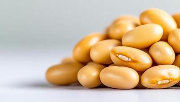Soya beans arranged on a light surface. Yellow soya beans are neatly piled on a light surface, showcasing their smooth texture and vibrant color. photo