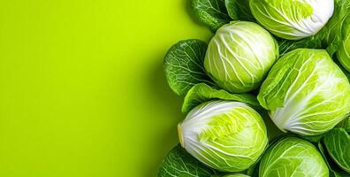 Fresh green cabbage on bright background. Cabbages arranged on a vibrant green surface showcase their crisp leaves and textures, creating an appealing display. photo