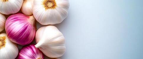 Garlic and shallots on light. Garlic and shallots are arranged artistically on a light surface, showcasing their vibrant colors and textures. photo