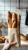Freshly baked baguettes held in paper bag against a cozy kitchen backdrop with warm lighting photo