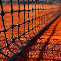 Close view of tennis net on clay court showcasing fine details during a sunny afternoon match photo