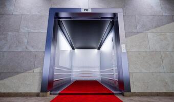 red carpet leading to open metallic silver elevator with concrete wall, Open elevator in business lobby photo