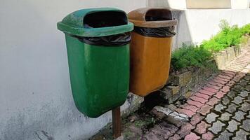 two orange and blue trash cans in the park photo