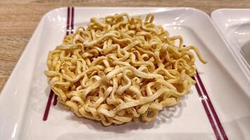 Crispy fried I Fu Mie or Yi Fu Mein Dry Noodles served on a white plate photo
