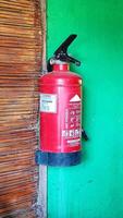 Fire extinguisher system on the green wall background, powerful emergency equipment photo