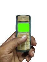 Close-up of a weathered, used mobile phone held in a hand. photo