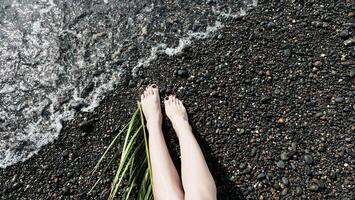 A woman's legs on the beach with grass photo