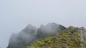 A mountain with fog and clouds in the background photo