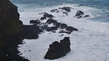 A view of the ocean from above with rocks and waves photo