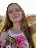 A woman with pink flowers in her hand photo