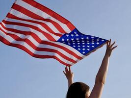 A woman holding an american flag in the air photo